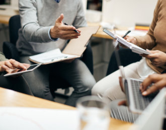 Close up of entrepreneurs having briefing during business meeting in office.